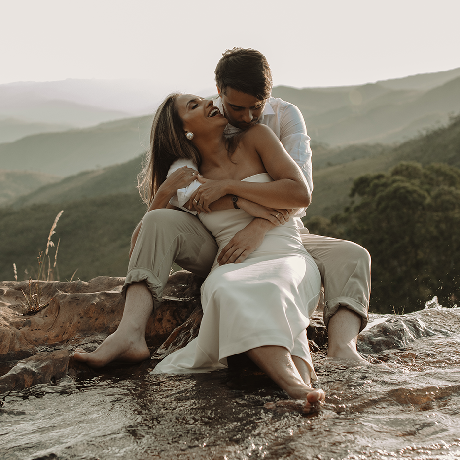Casal Bruna e Mateus durante ensaio pré-wedding ao ar livre, com luz suave do pôr do sol e gestos de carinho. Fotógrafa Nati Godinho captura emoção, amor e conexão natural entre os noivos.
