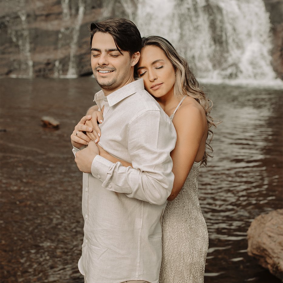 Casal Bruna e Mateus durante ensaio pré-wedding ao ar livre, com luz suave do pôr do sol e gestos de carinho. Fotógrafa Nati Godinho captura emoção, amor e conexão natural entre os noivos.